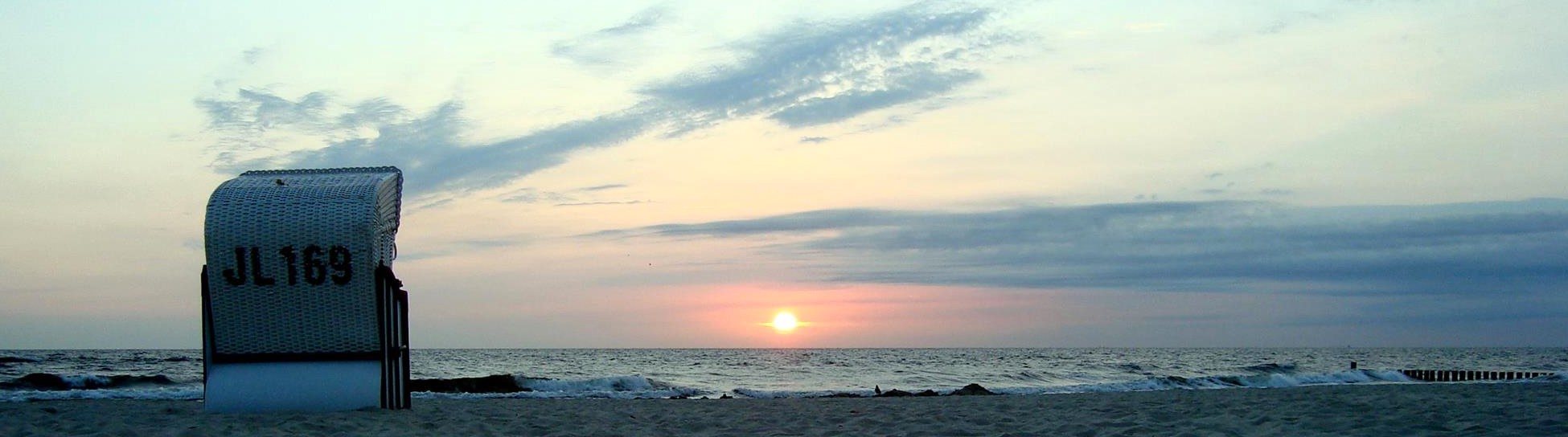 roofed wicker beach chair at the ocean + sunrise